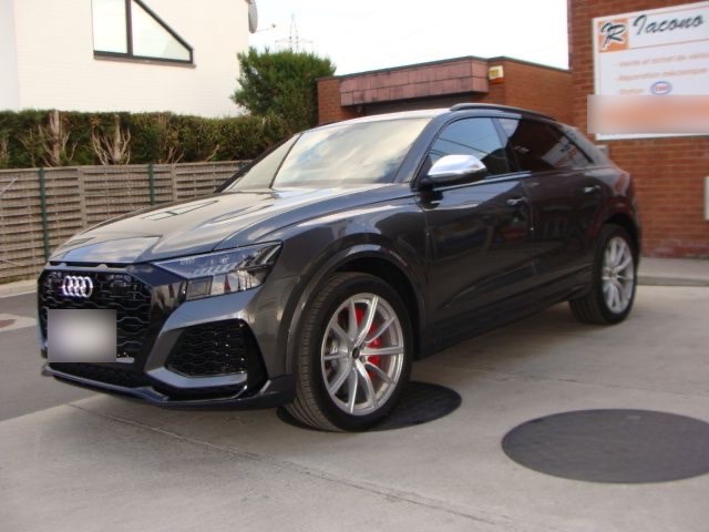 Un SUV Audi Q8 gris foncé devant le garage