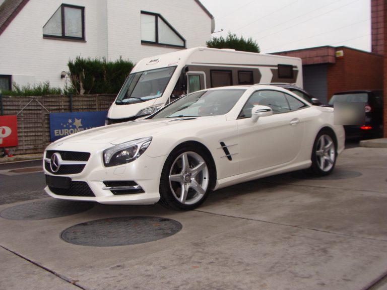 Une Mercedes-Benz SL blanche devant le garage