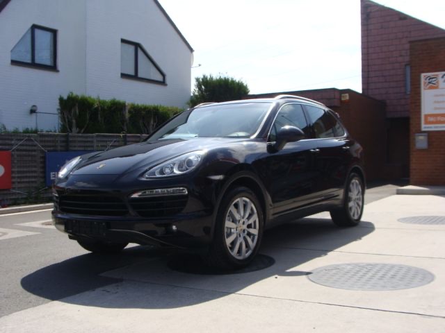 Un Porsche Cayenne noir devant le garage